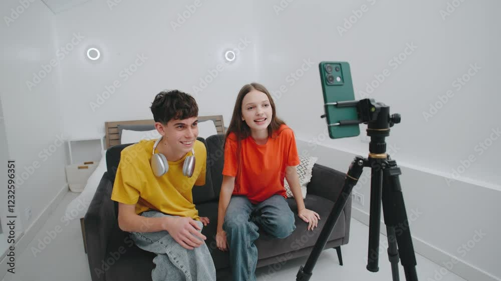 Young content creators engage with their audience while streaming live from a cozy indoor space during the afternoon Young content creators engage with their audience while streaming live from a cozy indoor space during the afternoon