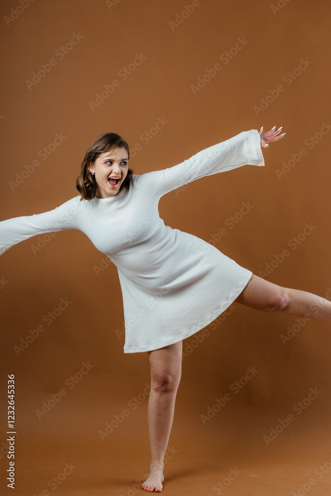 Naklejka premium A stylish and elegant young woman poses gracefully in a studio setting