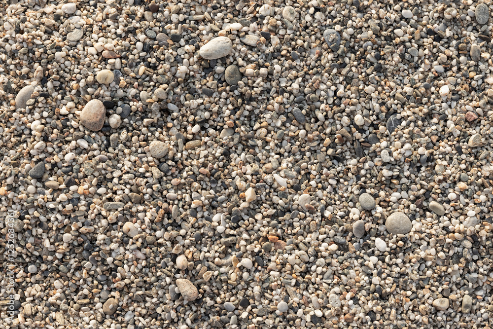 Coastal pebble mixed with coarse sand in a sunlight, top view Coastal pebble mixed with coarse sand in a sunlight, top view