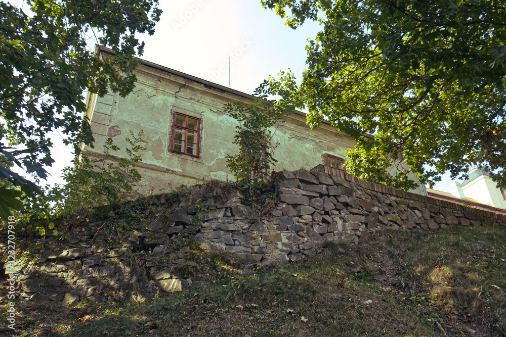 An old castle building on top of a hill. A shot from the park at the foot of the hill. Walls, park, trees, grass. Walls in front of the old castle building. An old castle building on top of a hill. A shot from the park at the foot of the hill. Walls, park, trees, grass. Walls in front of the old castle building.
