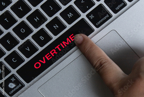 Cuadro en lienzo Close-up of Finger Pressing Laptop Key with Red Overtime Text for Workplace Prod