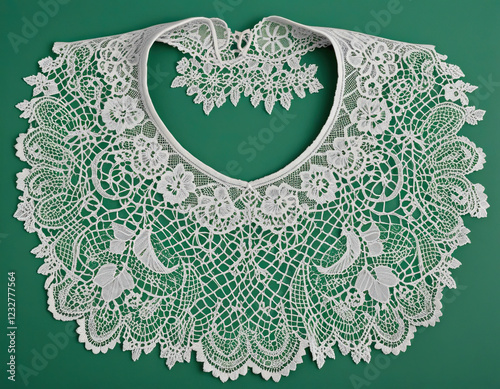 Delicate vintage lace collar with intricate patterns on a green background