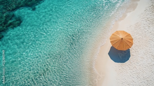 Relaxing beach view with a blue umbrella and clear turquoise waters on a sunn...