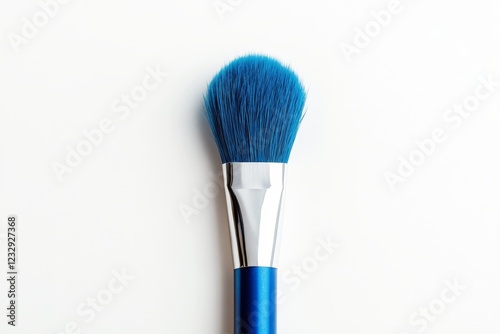 Artistic blue paint brush resting against a light background showcasing vibra...