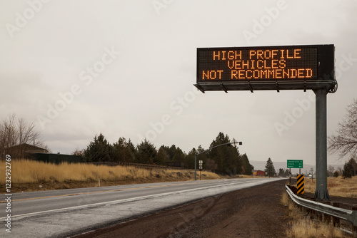 High wind warning sign on US Highway 395 in Johnstonville, Lassen County, California, advising high-profile vehicles against travel in stormy conditions. photo