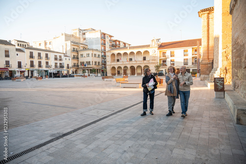 Wallpaper Mural Three senior friends strolling through a sunny historic square, enjoying a relaxed sightseeing experience Torontodigital.ca