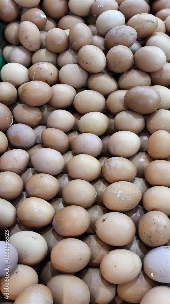 A high quantity of fresh brown eggs showcased in a marketplace setting, ideal for markets or kitchens. A high quantity of fresh brown eggs showcased in a marketplace setting, ideal for markets or kitchens.