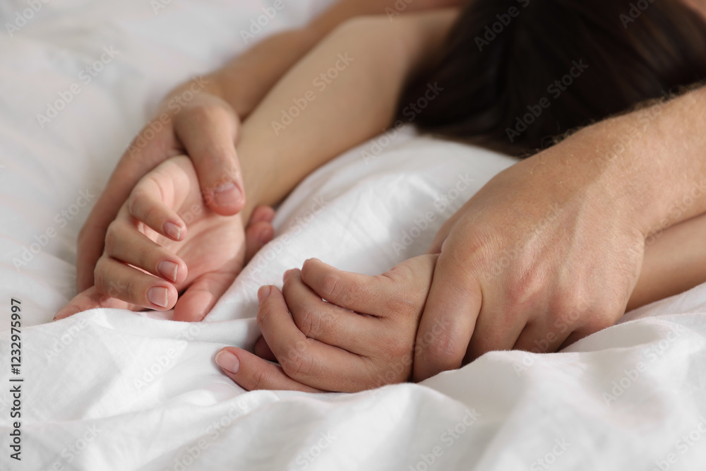 Lovely couple holding hands in bed, closeup Lovely couple holding hands in bed, closeup