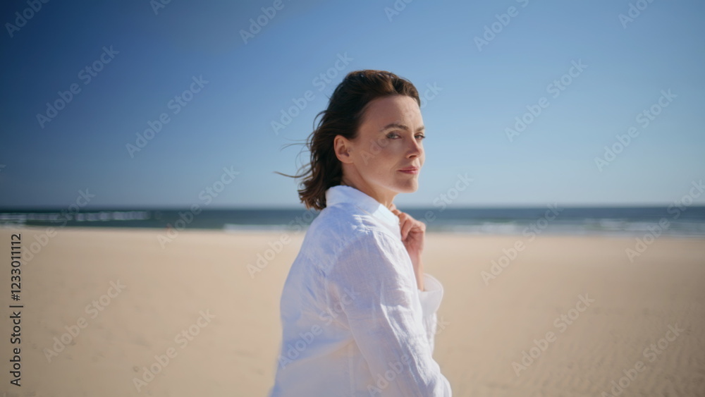 Serene woman strolling ocean shore in white shirt closeup. Carefree lady walking Serene woman strolling ocean shore in white shirt closeup. Carefree lady walking