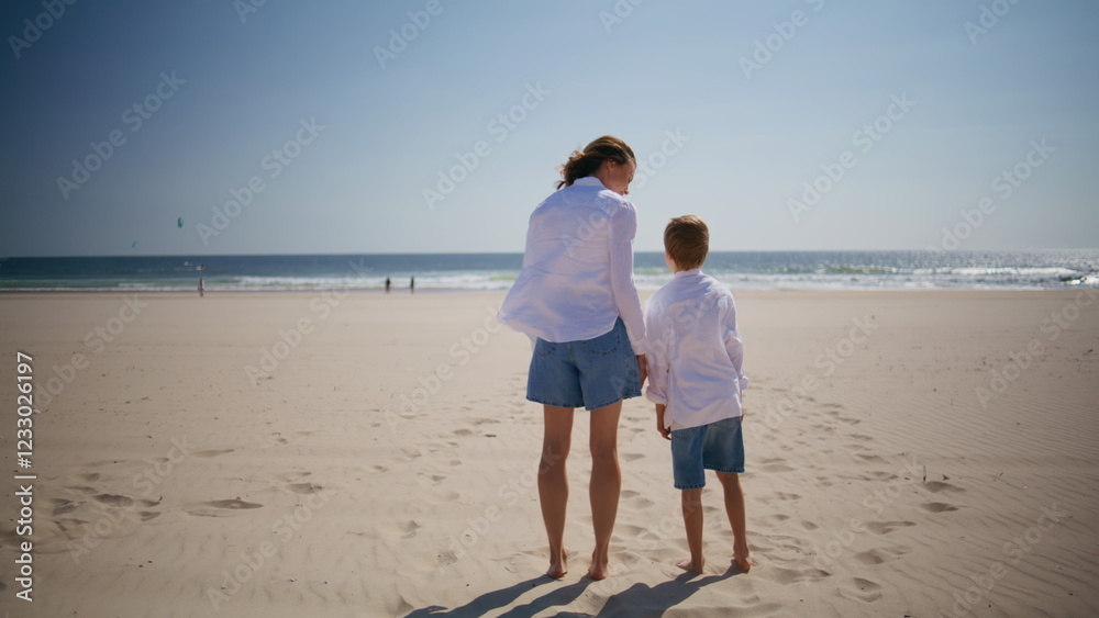 Mother son standing beach at summer vacation back view. Loving mom hugging boy Mother son standing beach at summer vacation back view. Loving mom hugging boy