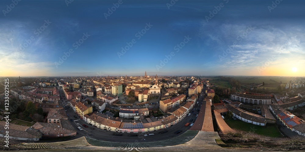 Fototapeta premium Panoramic drone shot capturing Cremona's cityscape during a serene winter sunset, showcasing the architectural beauty and urban layout of the city in Lombardy, Italy