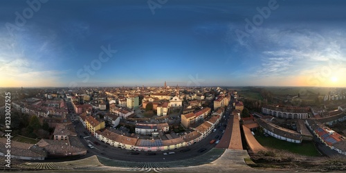 Fototapeta Naklejka Na Ścianę i Meble -  Panoramic drone shot capturing Cremona's cityscape during a serene winter sunset, showcasing the architectural beauty and urban layout of the city in Lombardy, Italy