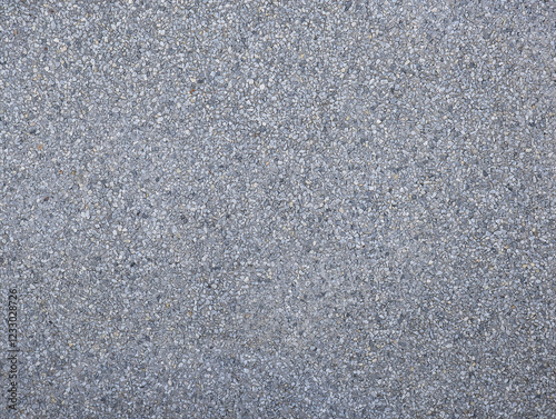 Grey concrete and small gravel stone wall texture. Gray hard surface with small stones background for house walls, plot division, facade. Architectural outdoor decoration. 