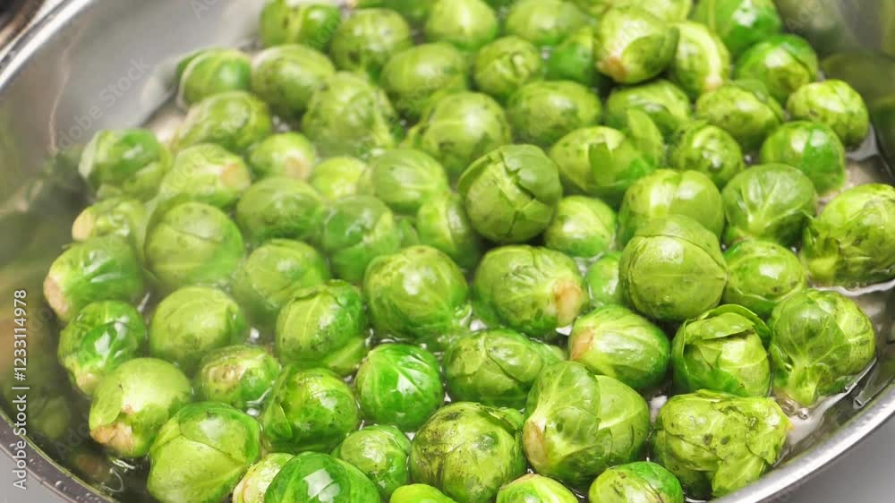 Top view of many green brussel sprouts boiling in hot vegetable oil inside a frying pan. Cooking fried sprouts of brussel sprouts fresh cabbage. Vegetarian food fried or boiled. Diet and vegetarianism Top view of many green brussel sprouts boiling in hot vegetable oil inside a frying pan. Cooking fried sprouts of brussel sprouts fresh cabbage. Vegetarian food fried or boiled. Diet and vegetarianism