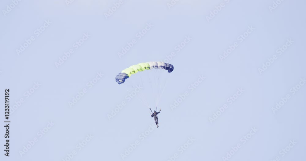 Person paragliding through air in slow motion near rocky desert cliff Person paragliding through air in slow motion near rocky desert cliff