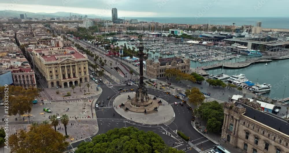Scenic aerial view of Placa de les Drassanes in Barcelona, Spain: Traffic moving along the waterfront, boats docked in the port, and stunning urban landscape. High quality 4k footage