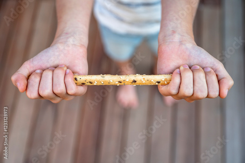 Child holding a crunchy breadstick photo