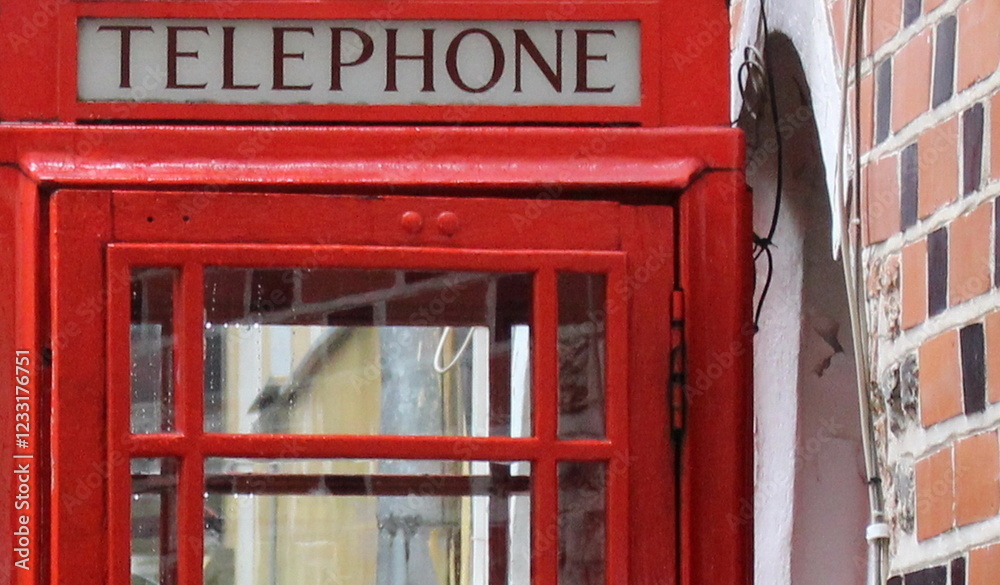 A red telephone booth in the courtyard of a city street. A red telephone booth in the courtyard of a city street.