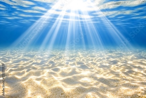 Underwater sunbeams illuminate ocean floor sand