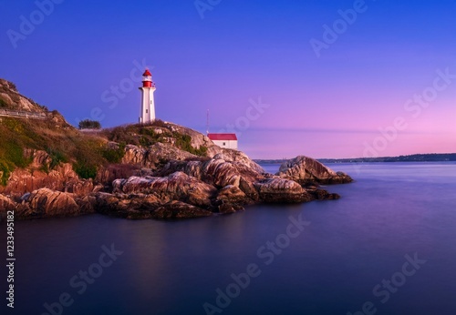 Lighthouse on rocky cliff at sunset against colorful sky. Lighthouse park. West Vancouver. British Columbia. Canada