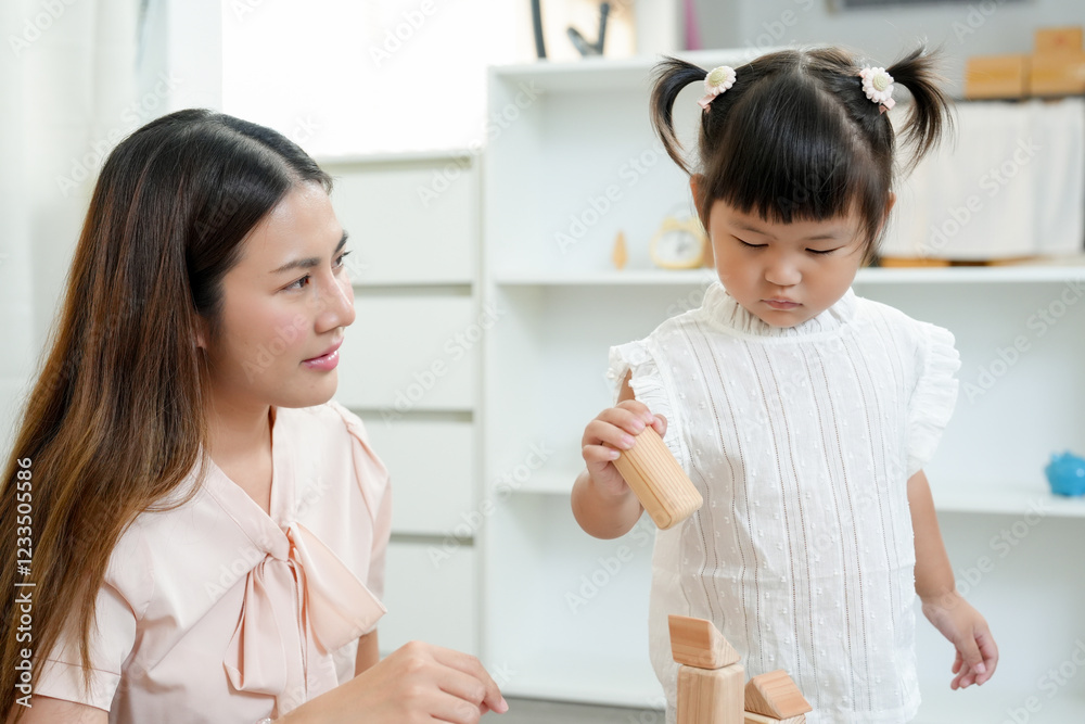 Asian teacher teaches children before enter kindergarten. Toddler stacking wooden blocks, developing motor skills and problem-solving abilities. Early childhood education through hands-on activities Asian teacher teaches children before enter kindergarten. Toddler stacking wooden blocks, developing motor skills and problem-solving abilities. Early childhood education through hands-on activities
