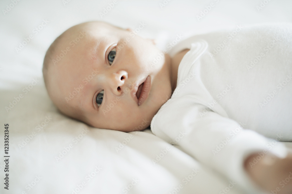 Baby, portrait and young newborn on a home bedroom in the morning calm and relax. Healthy smile, child face and a house with a toddler ready for a nap, sleeping and rest on a duvet and blanket Baby, portrait and young newborn on a home bedroom in the morning calm and relax. Healthy smile, child face and a house with a toddler ready for a nap, sleeping and rest on a duvet and blanket