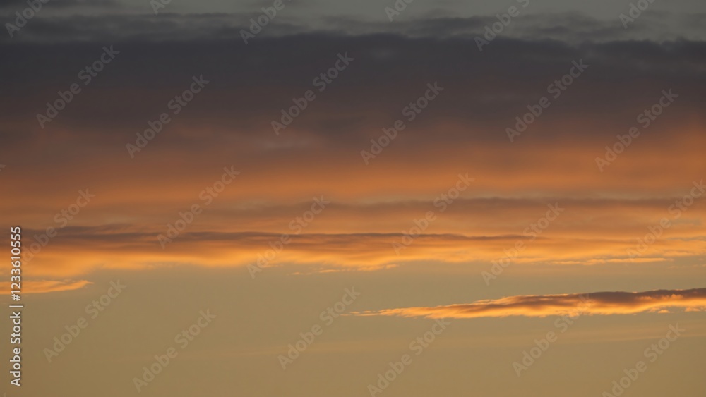 Fototapeta premium Serene Sunset Sky Layers of Golden and Gray Clouds