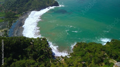 Bird eye view View of the coastline with hills and trees, cliffs, coral reefs and waves from the sea at Surumanis Beach, Kebumen, Central Java photo