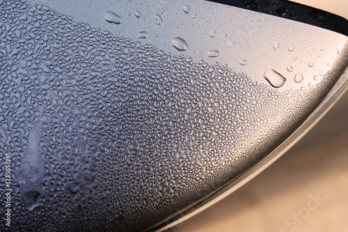 Water droplets on a stainless steel plate, close-up.