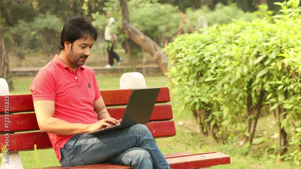 Young indian man working on laptop and do thumbs up while sitting in summer park. Wireless internet technology. 4k Young indian man working on laptop and do thumbs up while sitting in summer park. Wireless internet technology. 4k