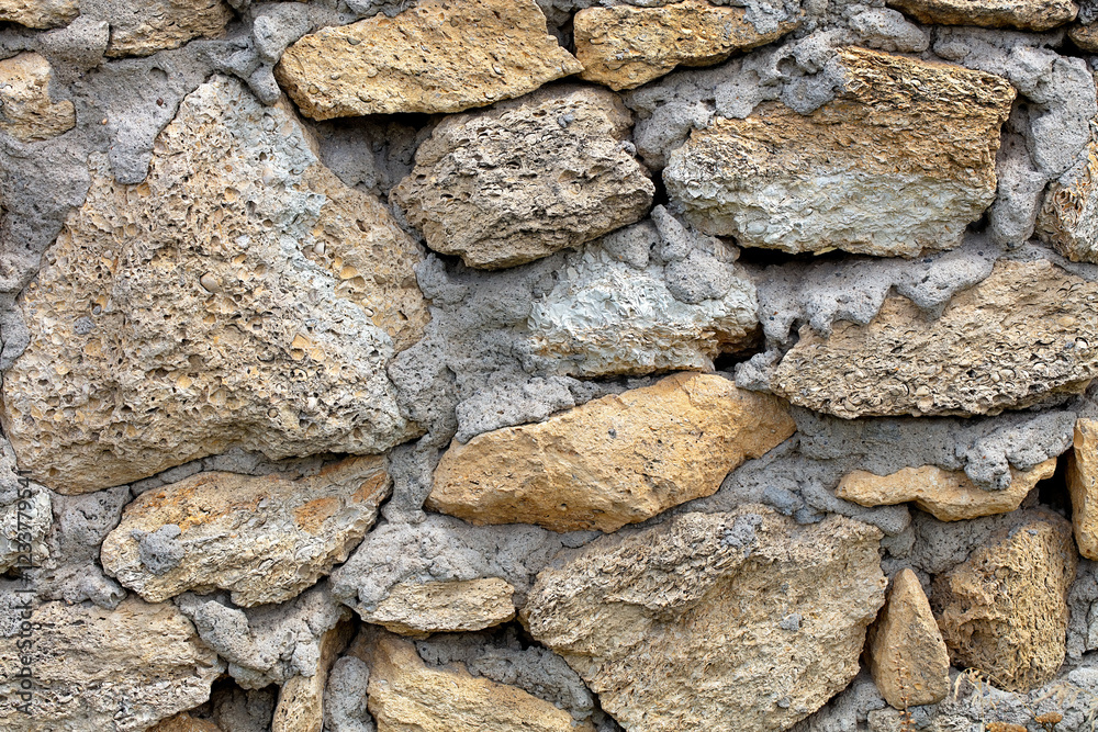 Textured wall crafted from natural stones showcasing rustic charm in muted tones