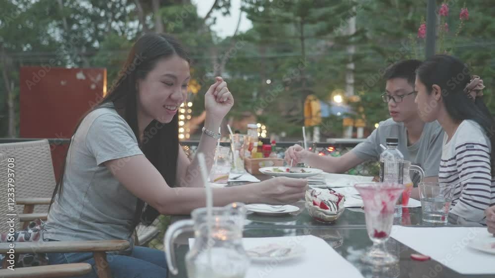 A family is eating dinner together at a restaurant. The man is eating with chopsticks and the woman is eating with a fork. The table is full of food and drinks A family is eating dinner together at a restaurant. The man is eating with chopsticks and the woman is eating with a fork. The table is full of food and drinks
