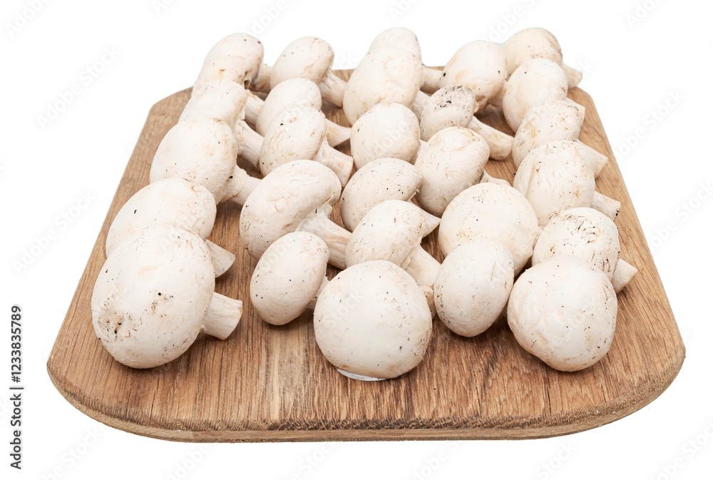 A pile of fresh champignon mushrooms on a wooden cutting board, isolated on a white background. A pile of fresh champignon mushrooms on a wooden cutting board, isolated on a white background.