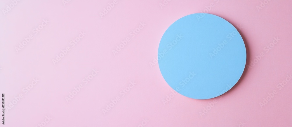 Obraz premium Blue circular object on a soft pink background with ample negative space for text placement