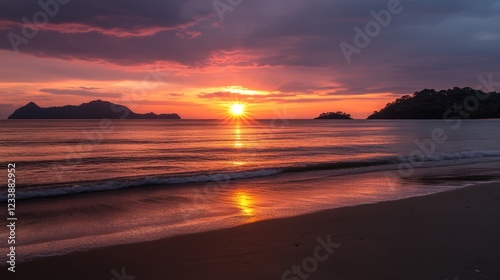 Sunset over calm beach with reflections on the water and silhouette of islands in the background, Copy Space available
