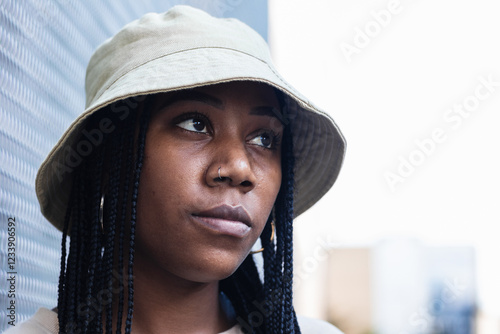 Serious self confident woman with dreadlocks hairstyle dressed in fashionable clothes photo