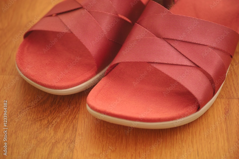 Pair of red sandals on a parquet floor. Close-up Pair of red sandals on a parquet floor. Close-up
