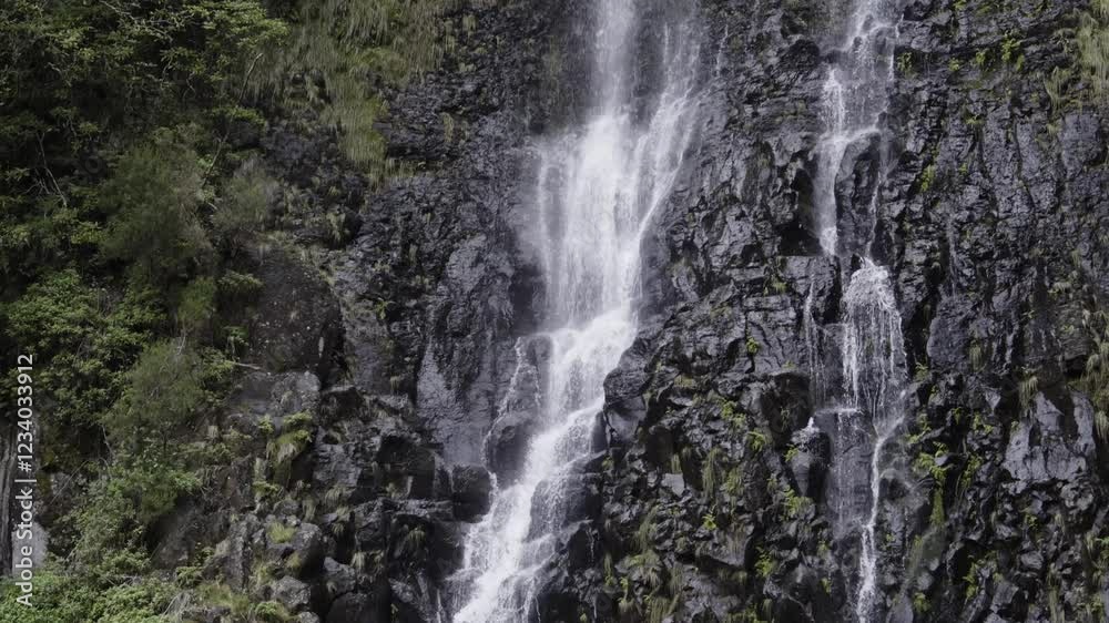 A captivating shot of a waterfall with the camera moving from top to bottom, following the cascading water over rugged rocks. Highlights the power and beauty of nature A captivating shot of a waterfall with the camera moving from top to bottom, following the cascading water over rugged rocks. Highlights the power and beauty of nature