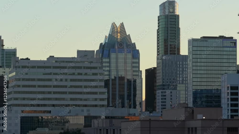 A wide drone shot at sunset decreasing elevation and centered on the Frost Bank Tower and some nearby skyscrapers in Austin Texas A wide drone shot at sunset decreasing elevation and centered on the Frost Bank Tower and some nearby skyscrapers in Austin Texas