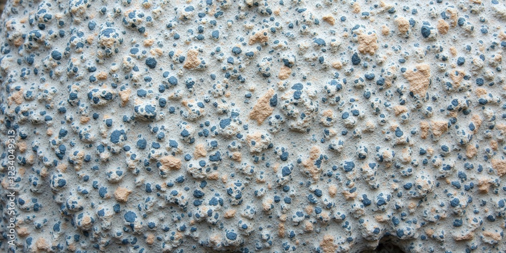 Rough-hewn, textured gray stone surface adorned with tiny blue and brown speckles. Clusters of small, uneven rocks scatter randomly, creating an intriguing natural mosaic. Rough-hewn, textured gray stone surface adorned with tiny blue and brown speckles. Clusters of small, uneven rocks scatter randomly, creating an intriguing natural mosaic.