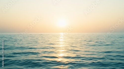 The sun sets over a tranquil ocean, painting the sky in hues of gold and peach, reflecting softly on the water's surface.