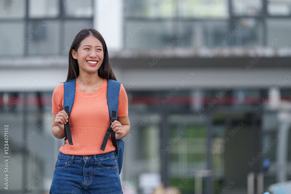 Happy young asian woman student walking outside a university campus building, holding her backpack straps, smiling brightly and gazing away with a sense of optimism and confidence Happy young asian woman student walking outside a university campus building, holding her backpack straps, smiling brightly and gazing away with a sense of optimism and confidence