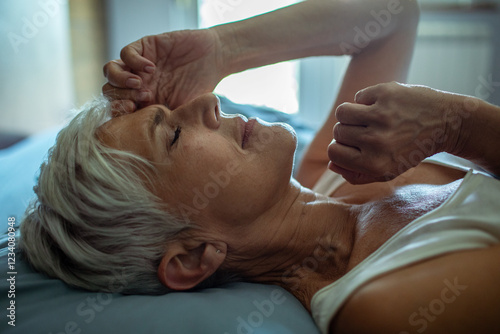 Senior woman waking up in the morning in bed