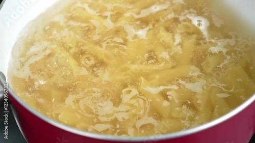 Raw pasta boiling in pot on stove Close view