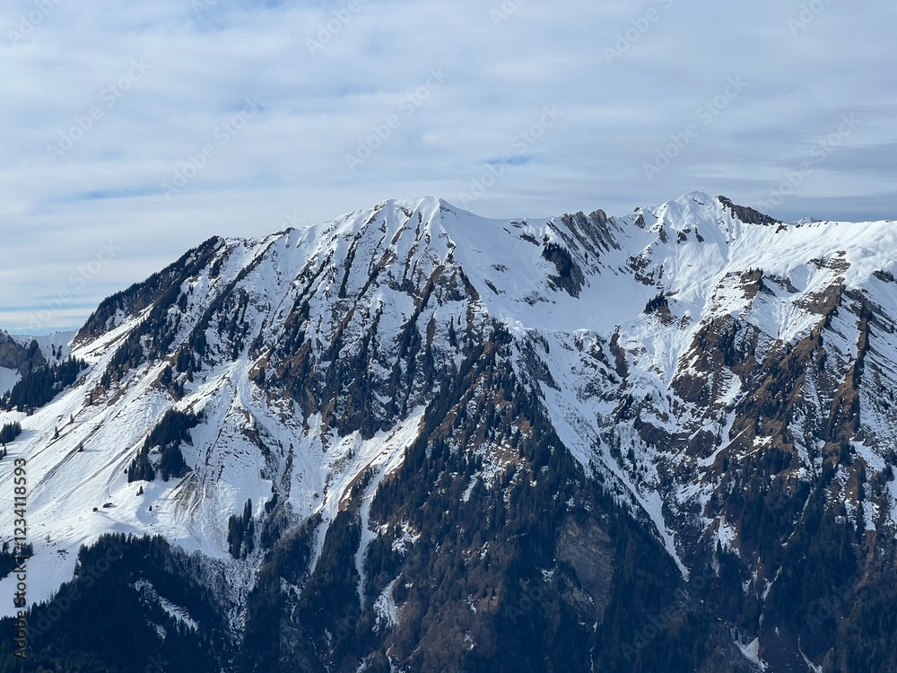 Obraz premium Beautiful sunlit and snow-capped alpine peaks above the Swiss tourist sports-recreational winter resort of Engelberg - Canton of Obwalden, Switzerland (Kanton Obwald, Schweiz)