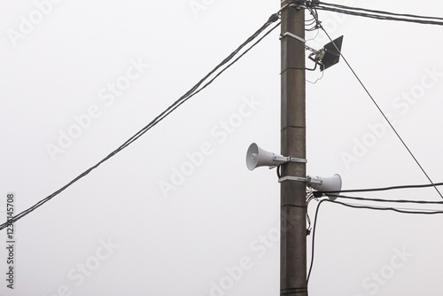 A Loudspeaker On A Pole With Wires On A Cloudy Day