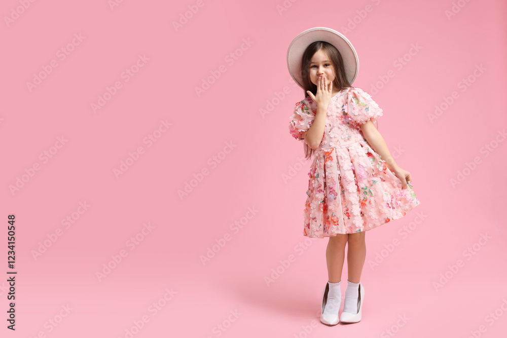 Stylish little girl wearing oversized high heeled shoes on pink background, space for text Stylish little girl wearing oversized high heeled shoes on pink background, space for text