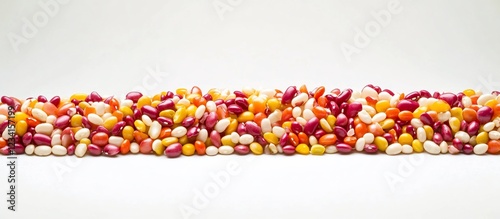 Colorful candy beans line on white; food background photo