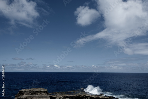 荒々しい波が打ち寄せる岩場と深い青の海
