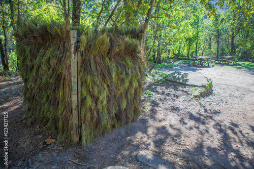 Dumpster hidden and camouflaged at Natural Park. Picnic area at bottom